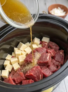 Adding ingredients to crock pot for steak bites