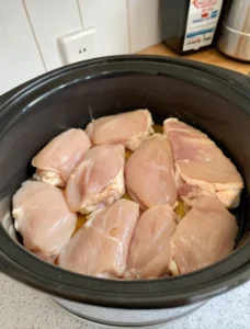 placing raw chicken in crock pot for pineapple teriyaki
